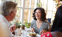 Smiling woman eating lunch with friends