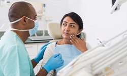 Woman with toothache talking to dentist