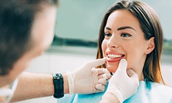 A dentist assessing a woman for cosmetic dentistry