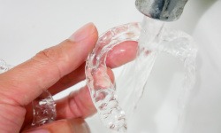 Closeup of patient rinsing clear aligner