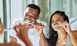 a couple brushing their teeth in the morning
