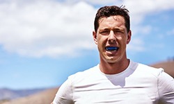 a man standing outside and wearing a mouthguard