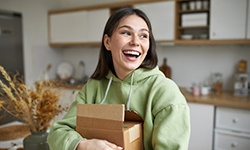 a woman smiling while holding a package